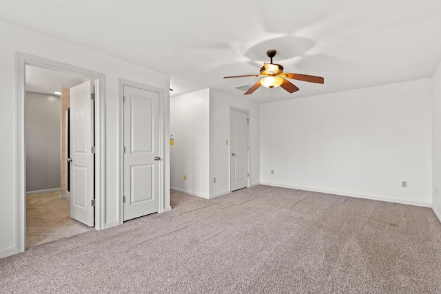 interior space featuring light carpet, a ceiling fan, and baseboards