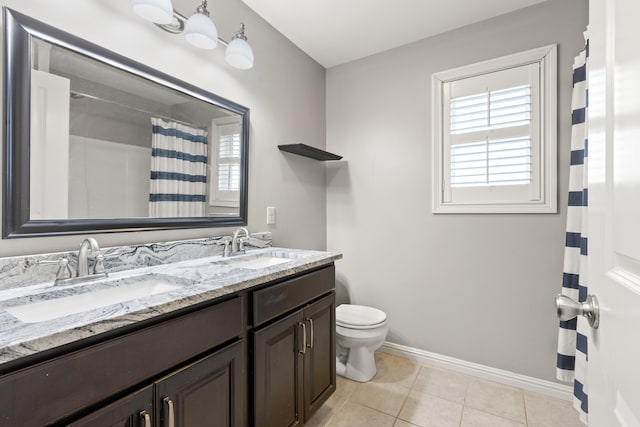 full bath with baseboards, toilet, a sink, and double vanity
