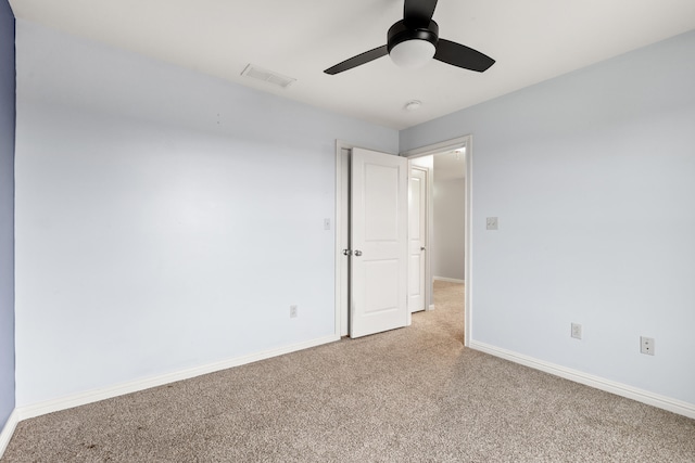 spare room featuring light carpet, baseboards, visible vents, and a ceiling fan