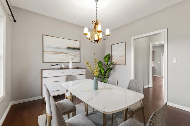 dining room with dark wood-type flooring, baseboards, and a notable chandelier