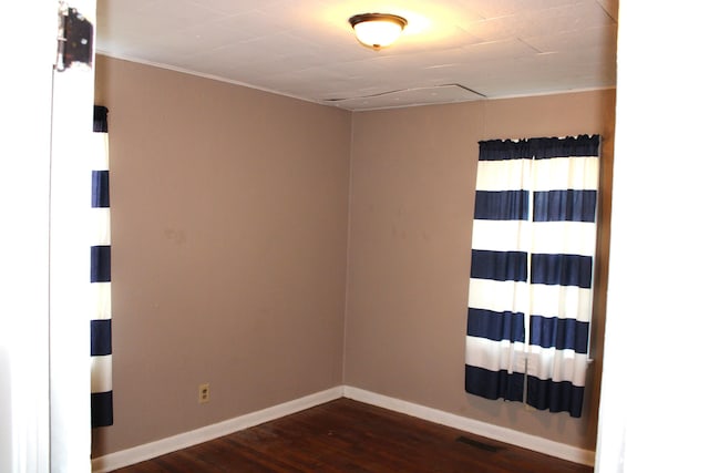 unfurnished room with dark wood-style floors and baseboards