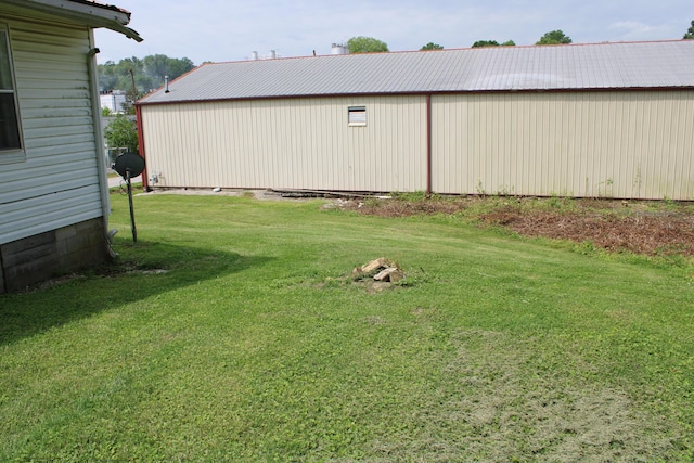 view of grassy yard featuring an outbuilding and an outdoor structure
