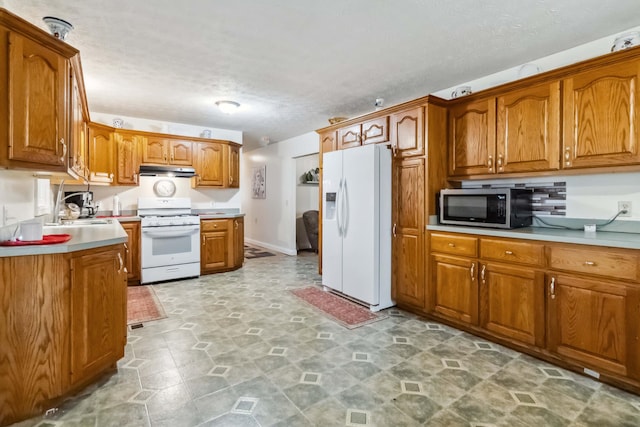 597 Snow Creek Rd, Clay City, KY 40312 - kitchen with brown cabinetry, a textured ceiling, a sink, and white appliances