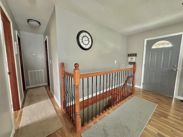entryway with visible vents, wood finished floors, and baseboards