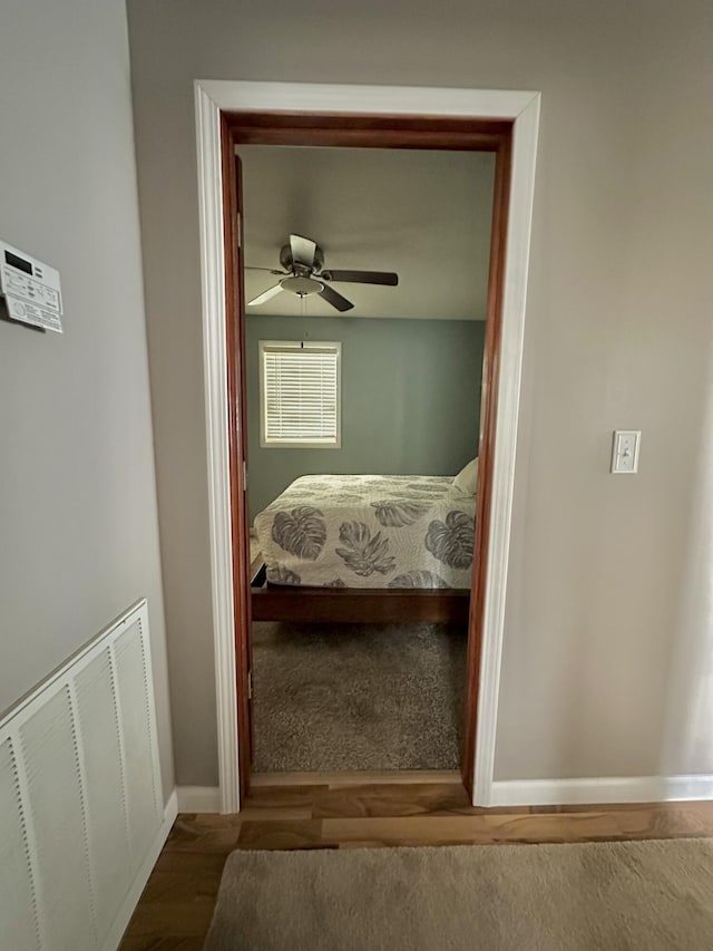 interior space with wood finished floors, visible vents, a ceiling fan, and baseboards