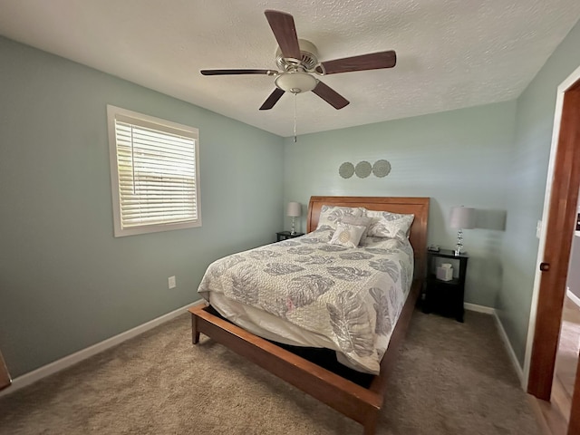 carpeted bedroom featuring a textured ceiling, ceiling fan, and baseboards