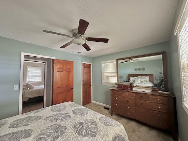 carpeted bedroom featuring a textured ceiling, ceiling fan, and baseboards