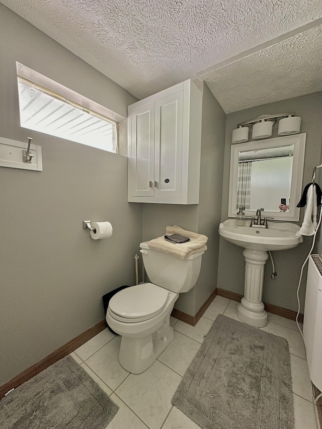 bathroom with tile patterned floors, toilet, and a textured ceiling