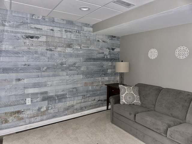 carpeted living room featuring visible vents and a paneled ceiling