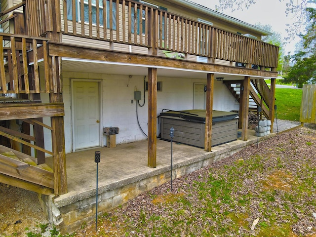 exterior space with a deck, stairs, and a hot tub