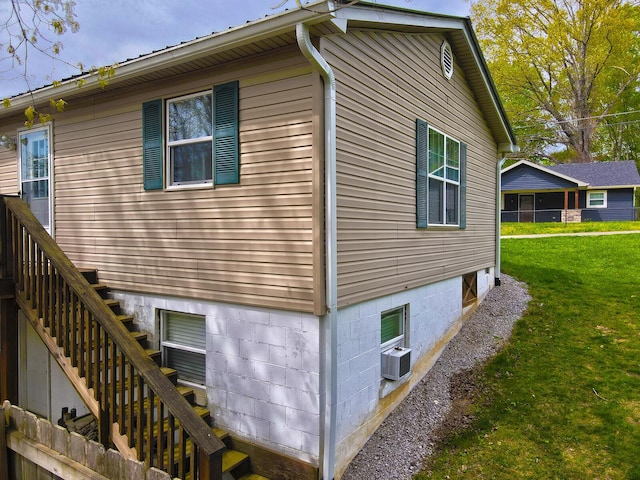 view of side of property featuring stairway and a yard