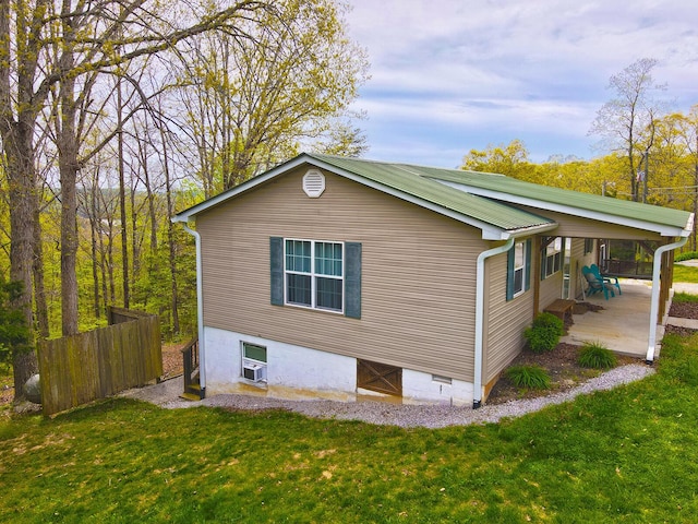 view of side of home with fence and a yard
