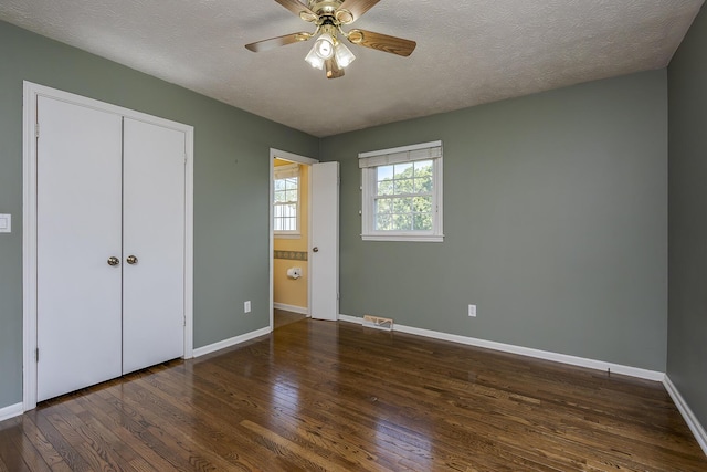 unfurnished bedroom with baseboards, wood finished floors, and a textured ceiling