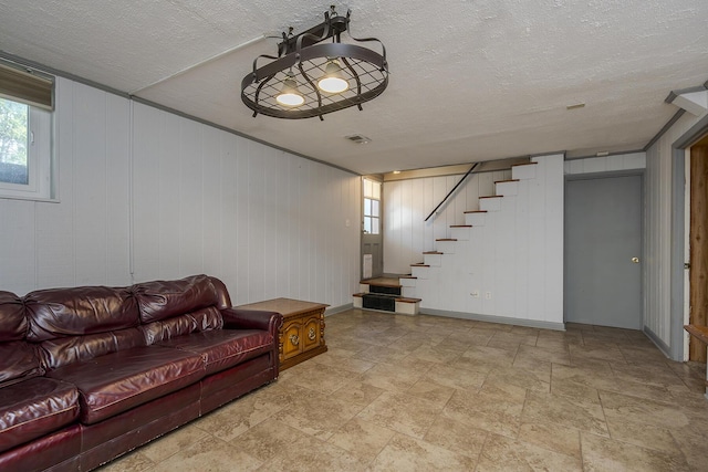 living area with visible vents, stairway, a textured ceiling, and stone finish floor