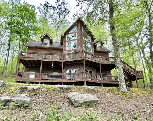 rear view of house featuring a wooden deck