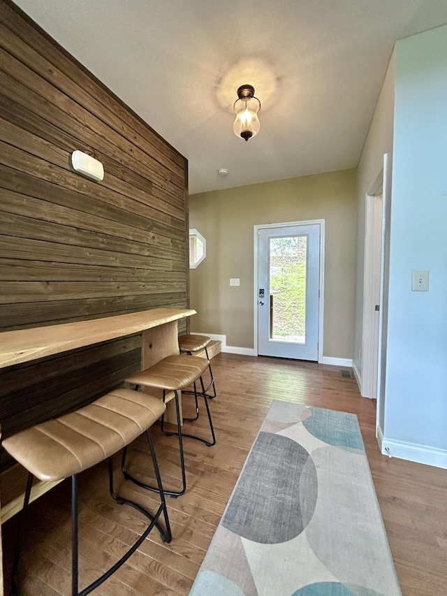 foyer with baseboards and wood finished floors