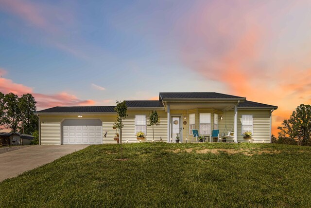 view of front of home featuring a lawn, a garage, covered porch, and concrete driveway