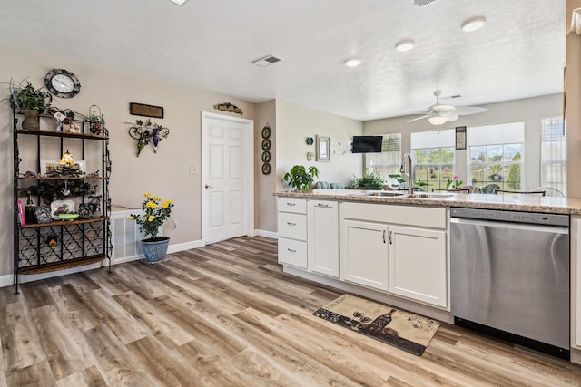 kitchen featuring ceiling fan, dishwasher, a sink, baseboards, and white cabinets