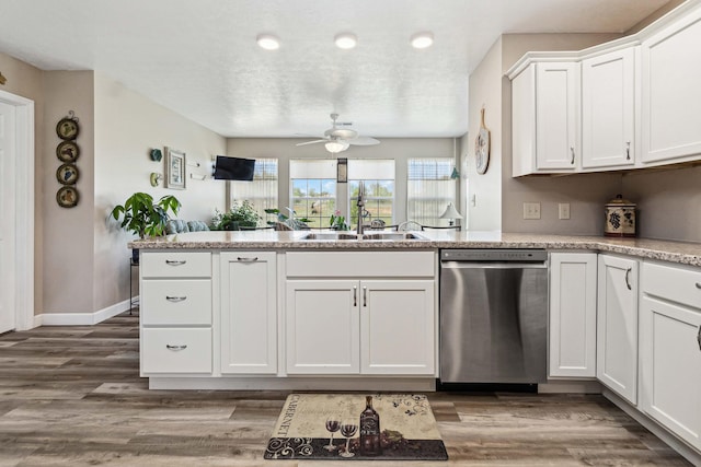 kitchen featuring a peninsula, ceiling fan, white cabinets, a sink, and dishwasher