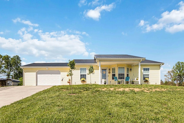 ranch-style house featuring concrete driveway, a front lawn, metal roof, an attached garage, and a porch