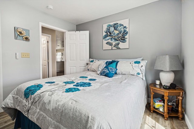 bedroom featuring baseboards and wood finished floors