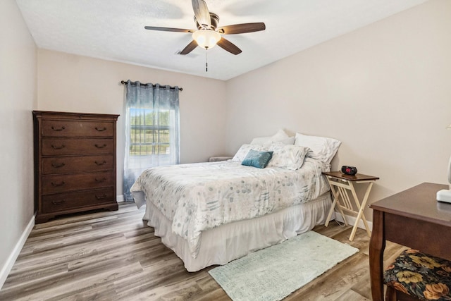 bedroom featuring baseboards, ceiling fan, and light wood-style floors
