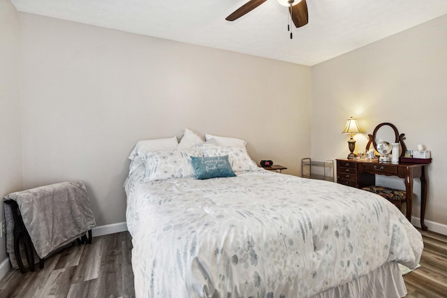 bedroom featuring a ceiling fan, baseboards, and wood finished floors
