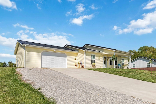 ranch-style house with a front lawn, an attached garage, concrete driveway, and metal roof