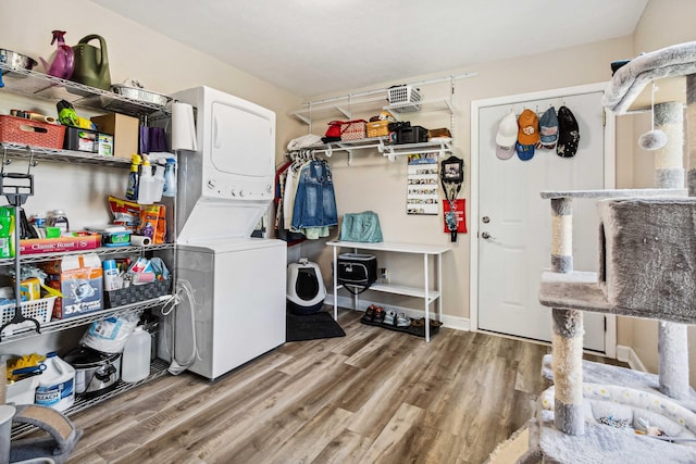 laundry area with laundry area, stacked washer and dryer, and wood finished floors