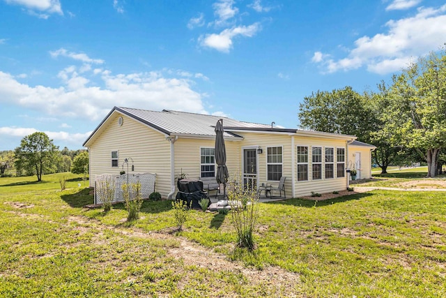 rear view of house with a lawn and a patio area