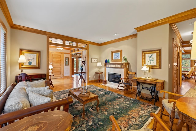 living room featuring crown molding, baseboards, a glass covered fireplace, and wood finished floors