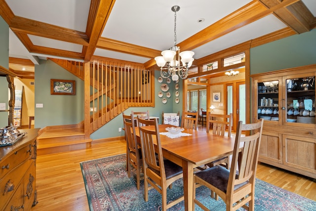 dining room featuring stairway, a notable chandelier, light wood-style floors, and beam ceiling