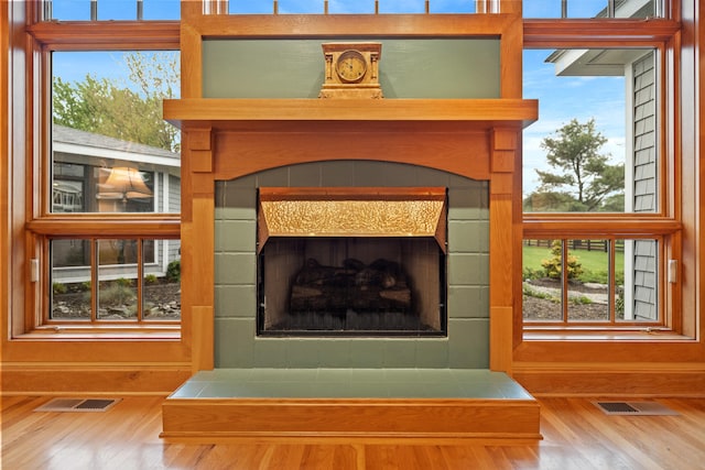 interior details with visible vents, wood finished floors, and a fireplace