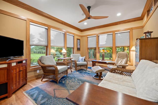 living area featuring light wood-type flooring, baseboards, ceiling fan, ornamental molding, and recessed lighting
