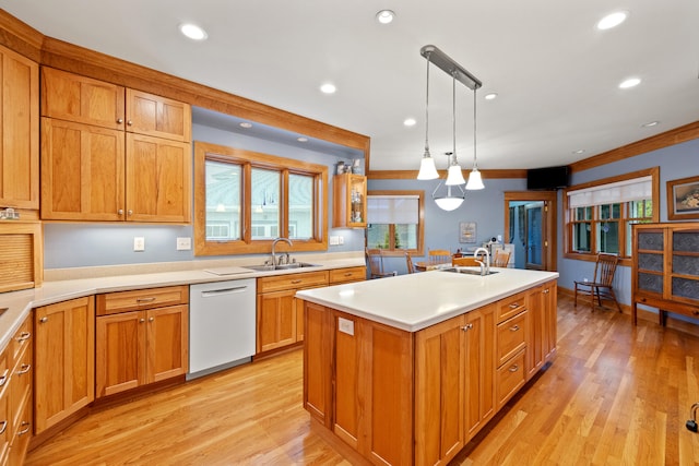 kitchen featuring light wood finished floors, dishwasher, light countertops, and a sink