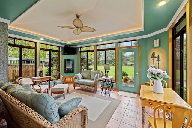 sunroom / solarium featuring a tray ceiling, tile patterned flooring, and a healthy amount of sunlight