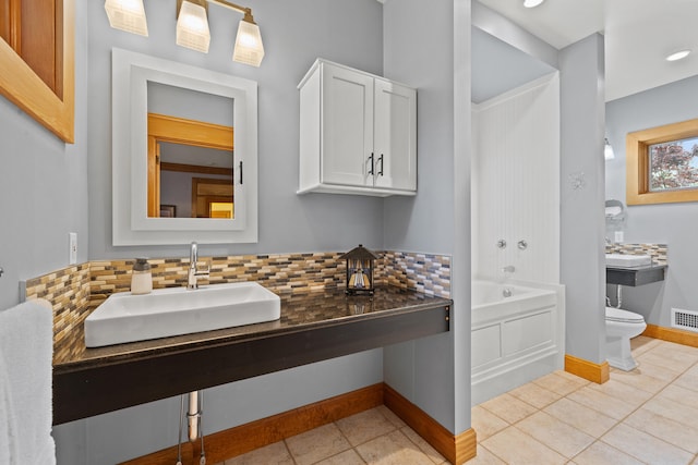 bathroom with a sink, toilet, visible vents, tile patterned flooring, and decorative backsplash