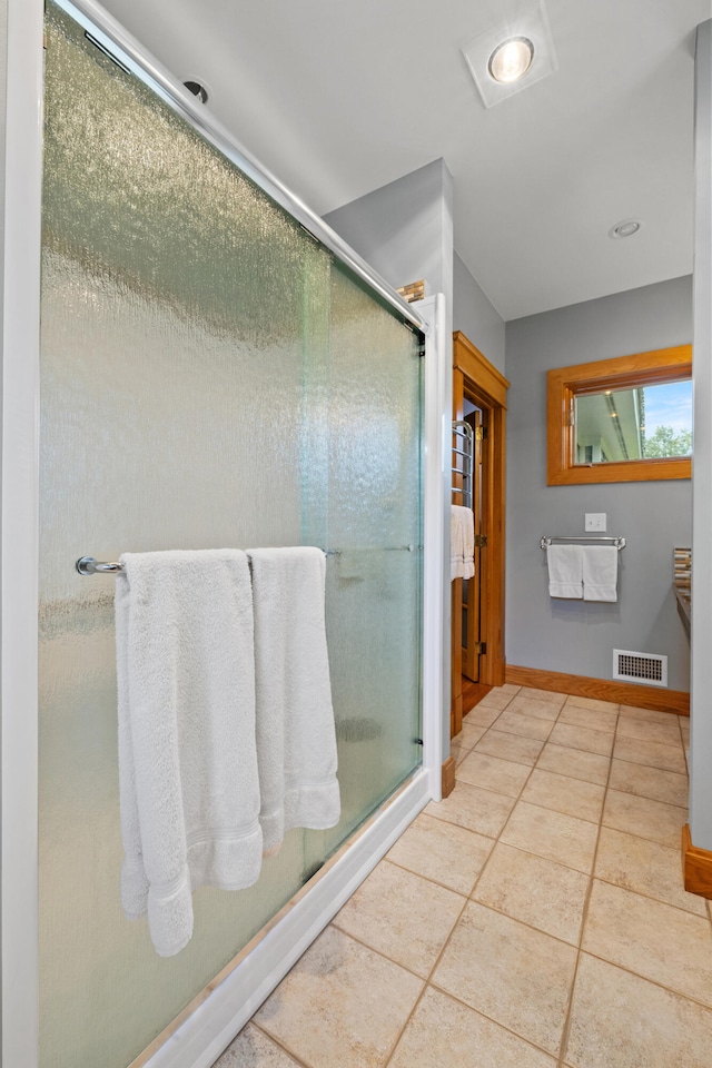 bathroom with tile patterned flooring, baseboards, a shower stall, and visible vents