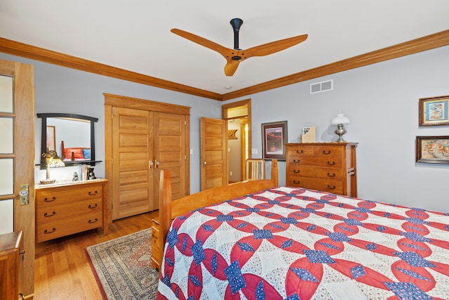 bedroom featuring crown molding, visible vents, wood finished floors, and ceiling fan