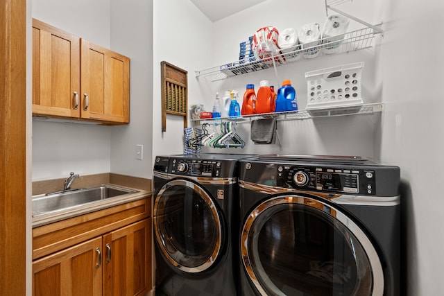laundry room with washer and dryer, cabinet space, and a sink
