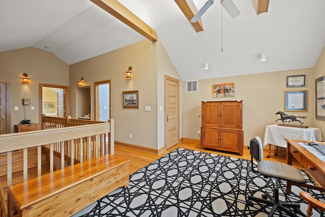 home office featuring a ceiling fan, baseboards, visible vents, vaulted ceiling, and light wood-style floors