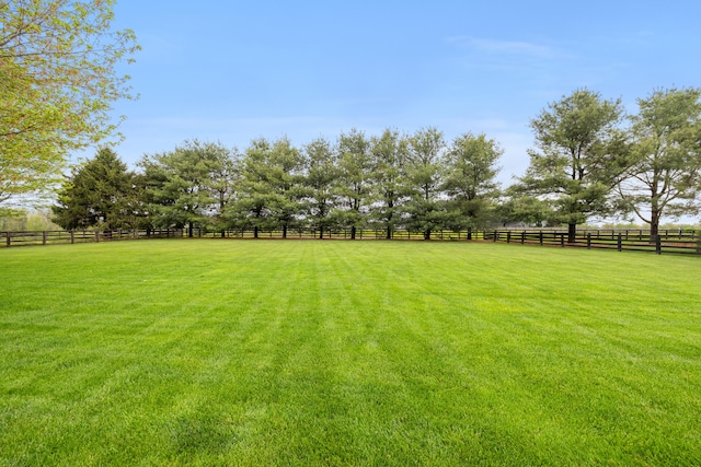 view of yard with a rural view and fence