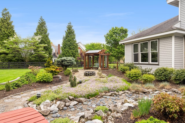 view of yard with a fire pit, fence, and a gazebo