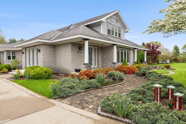 view of home's exterior with a yard, stone siding, and a shingled roof