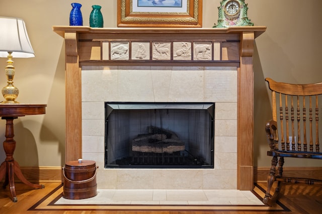 interior details featuring wood finished floors and a tile fireplace