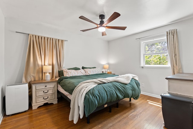 bedroom featuring baseboards, ceiling fan, and wood-type flooring
