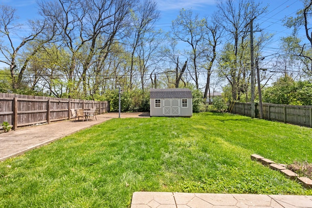view of yard with an outbuilding, a storage shed, a patio, and a fenced backyard