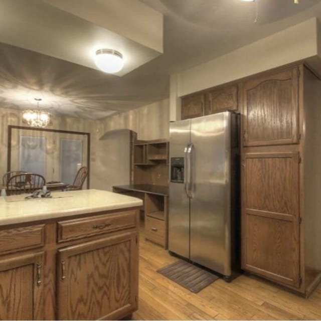 102 Locust St, Manchester, KY 40962 - kitchen with light countertops, stainless steel fridge, light wood-style floors, and an inviting chandelier