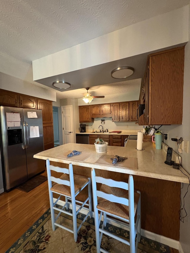 102 Locust St, Manchester, KY 40962 - kitchen featuring a sink, a textured ceiling, stainless steel fridge with ice dispenser, light countertops, and a peninsula