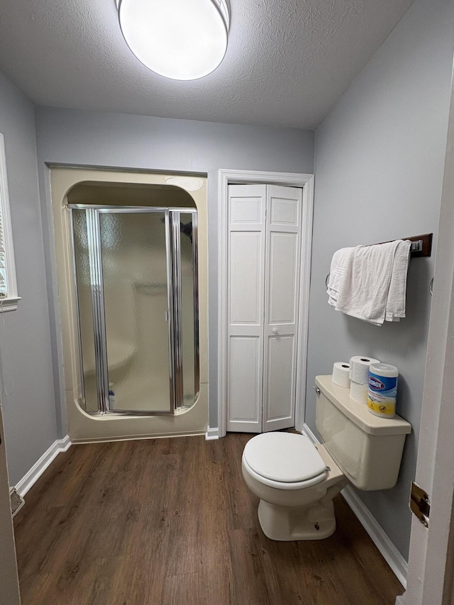 102 Locust St, Manchester, KY 40962 - bathroom with a shower stall, wood finished floors, toilet, baseboards, and a textured ceiling